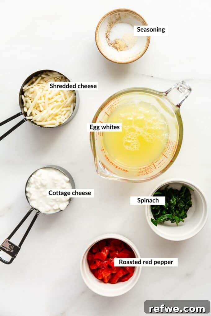 Lean Protein Egg Cups 3 A flat lay photograph displaying all the fresh ingredients needed for egg white bites: egg whites, cottage cheese, shredded cheese, bell peppers, spinach, and seasonings.