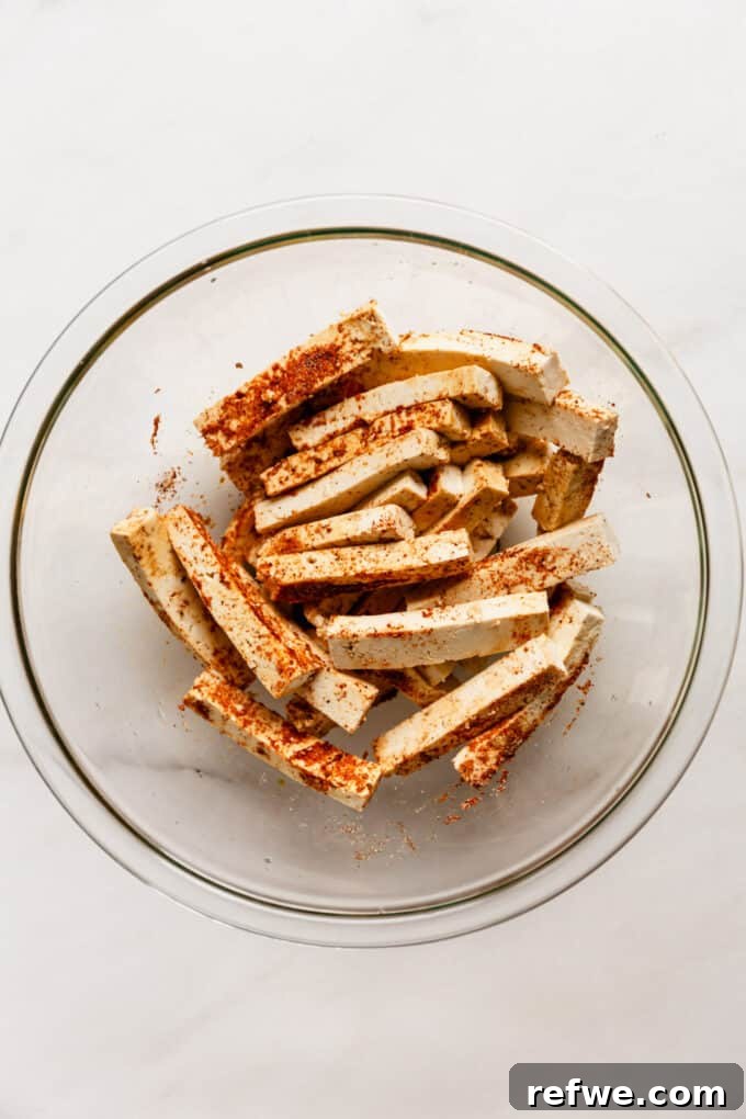 Sizzling Tofu Fajitas 4 tofu strips in a mixing bowl with seasoning