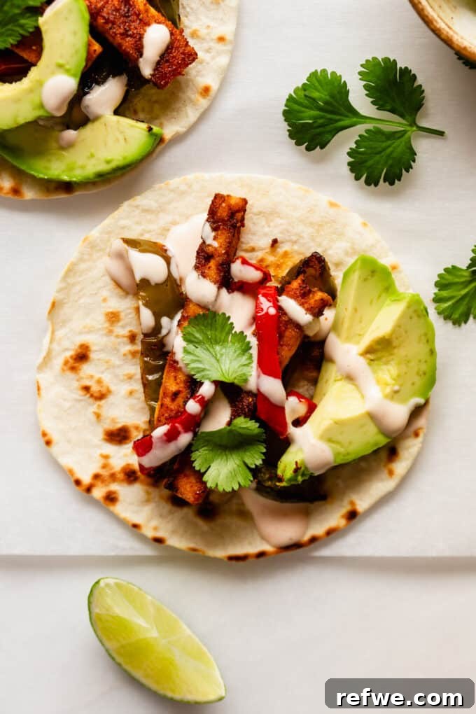 Sizzling Tofu Fajitas 7 a tofu fajita with avocado and chipotle crema on a taco shell