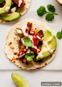 a tofu fajita with avocado and chipotle crema on a taco shell