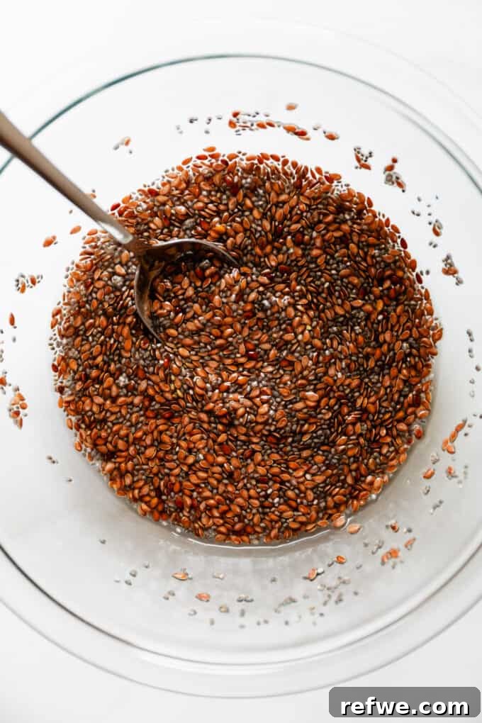 Effortless Flaxseed Crisps 5 A close-up view of flax and chia seeds fully submerged in water within a mixing bowl, beginning to swell and form a thick, natural gel after soaking.