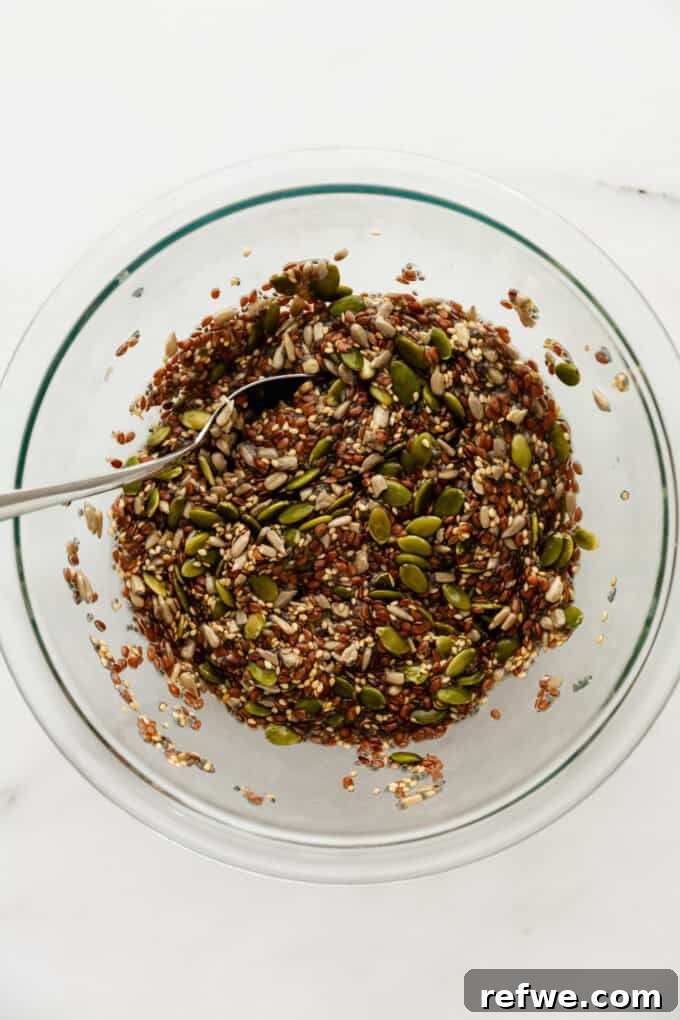 Effortless Flaxseed Crisps 7 The fully combined mixture of flax, chia, sunflower, sesame, and pumpkin seeds with water, forming a cohesive and spreadable dough in a mixing bowl.