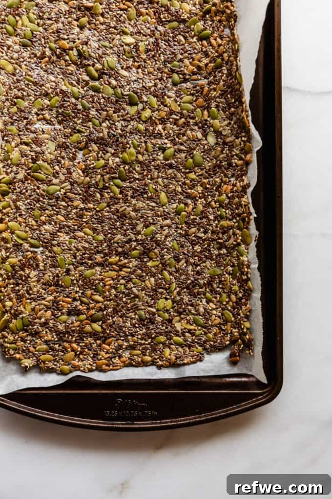 Effortless Flaxseed Crisps 9 A sheet of freshly baked, golden-brown flax crackers on parchment paper, perfectly crisp and ready to be cooled and broken apart.