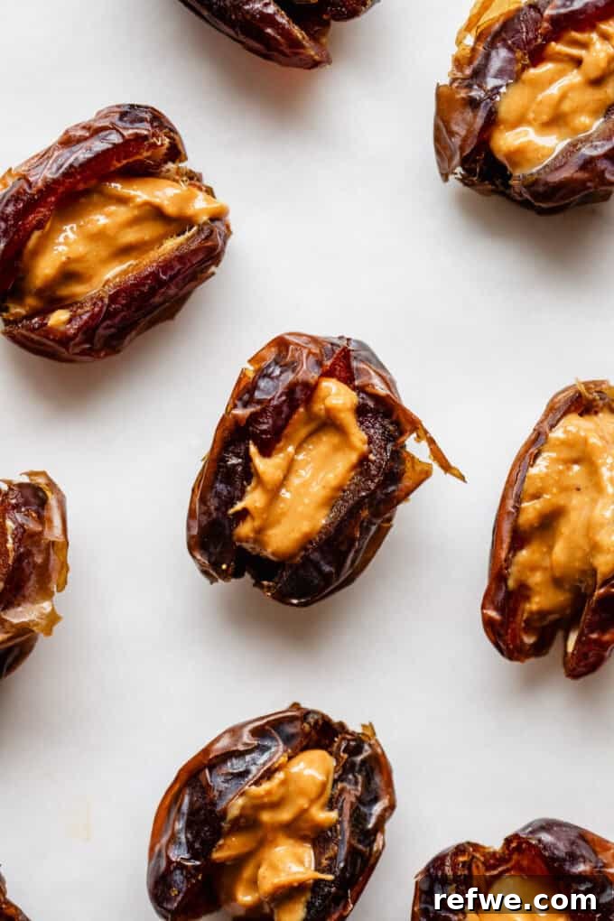 Snickers Dream Dates 5 Medjool dates meticulously stuffed with creamy peanut butter, showcasing the rich filling and readiness for the next delicious layer in the Date Snickers recipe.