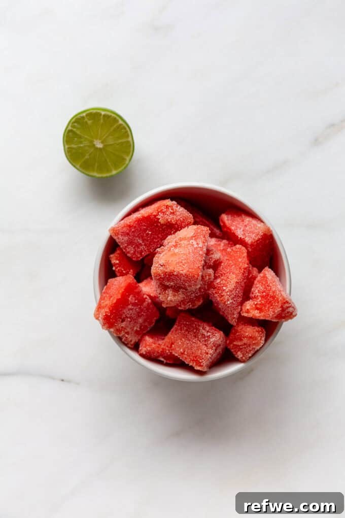 Crimson Crush 3 Two key ingredients for a watermelon slushie: fresh watermelon chunks and vibrant green limes, ready for blending.