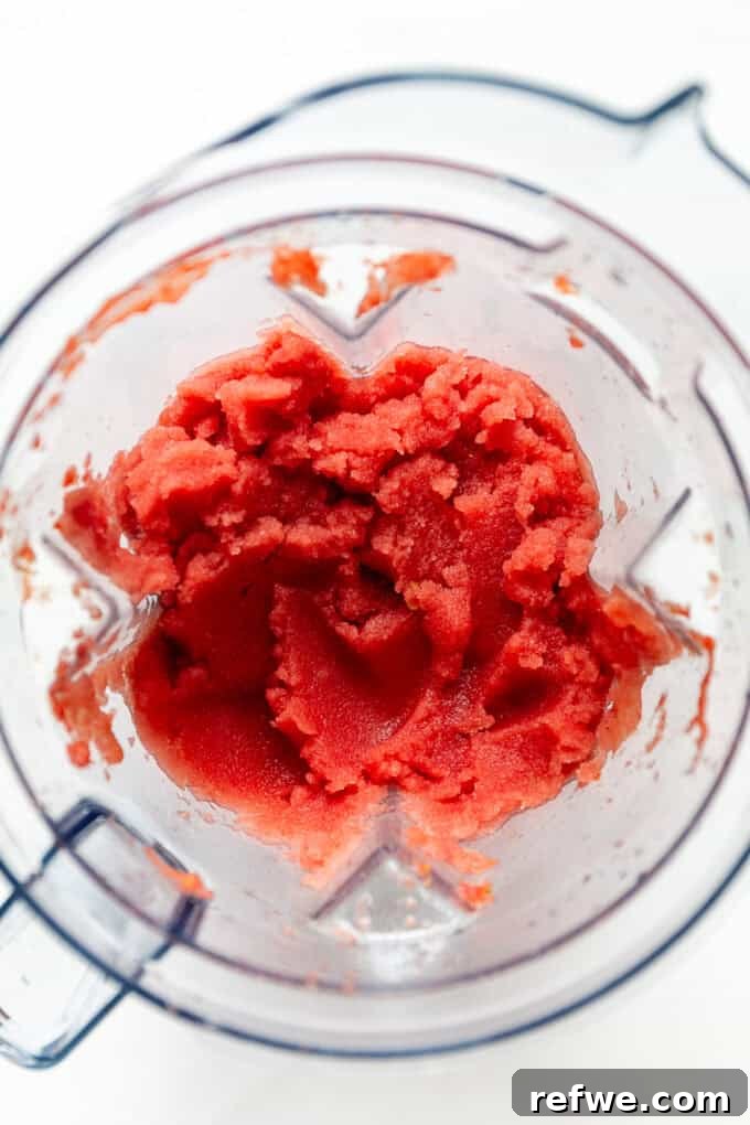 Crimson Crush 5 The blender is actively mixing frozen watermelon and lime juice, showing the formation of a smooth, icy watermelon slushie.