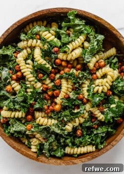 A vibrant Kale Caesar Pasta Salad served in a rustic wood mixing bowl, ready to be enjoyed.