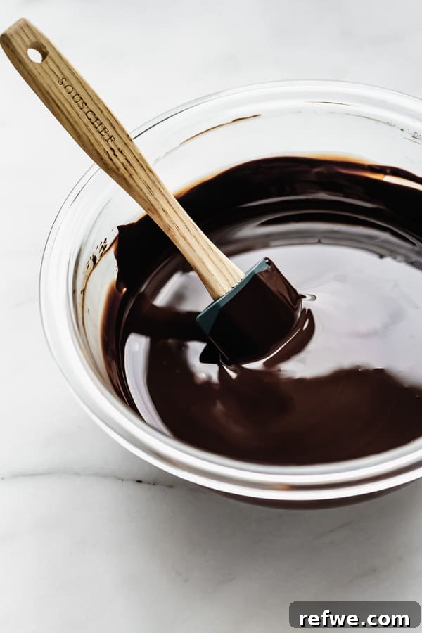 Decadent Snickers Overnight Oats 8 A mixing bowl of dark chocolate chips with a spatula in it, prepared for melting.
