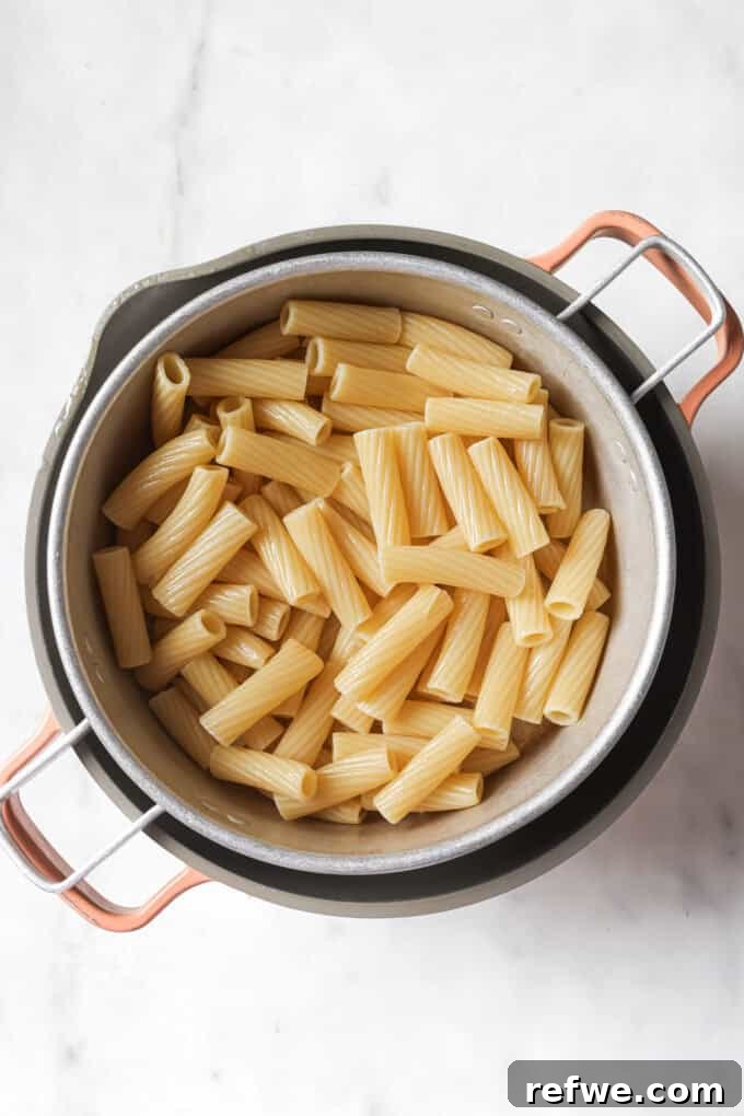 The Proposal Pasta 4 Cooked rigatoni pasta being drained in a colander after boiling.