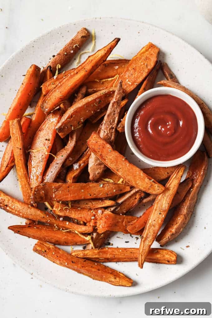 Crispy Air-Fried Sweet Potato Wedges 2 Crispy sweet potato wedges on a white plate with a side of ketchup, ready to be served