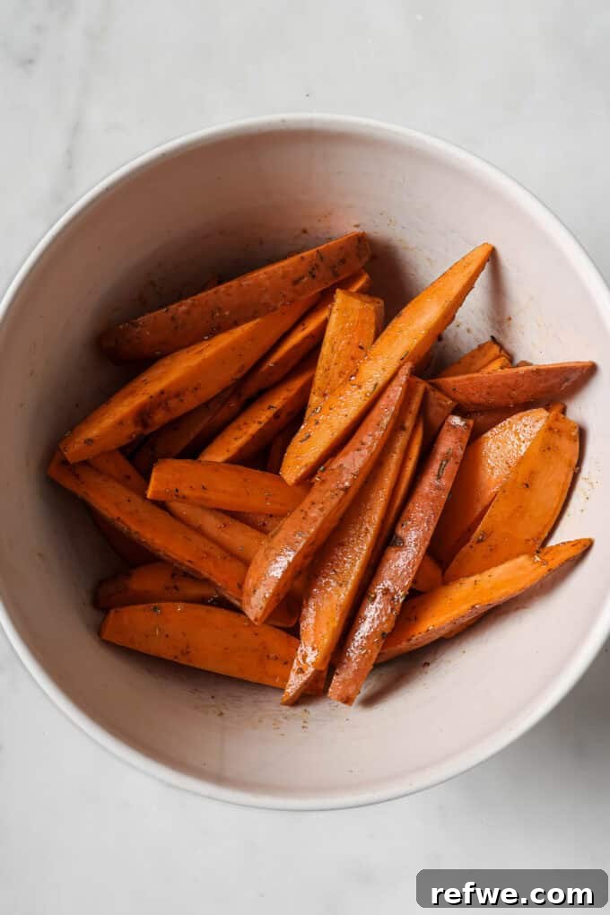 Crispy Air-Fried Sweet Potato Wedges 5 Sliced sweet potato wedges coated in olive oil and seasoning, tossed together in a clear mixing bowl