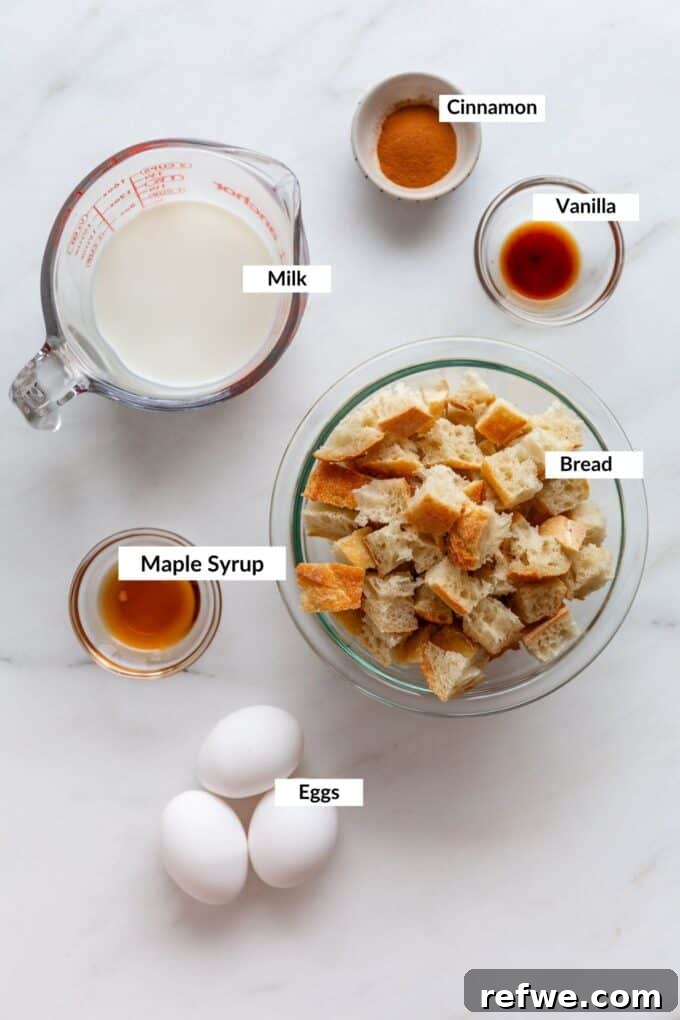 A flat lay of fresh ingredients laid out on a kitchen counter, including bread, eggs, milk, and maple syrup, all ready to be transformed into delicious French toast muffins.