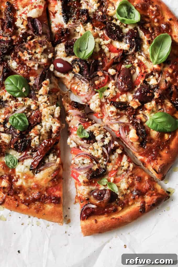Sun-Kissed Mediterranean Pizza 2 sliced mediterranean pizza topped with fresh basil leaves