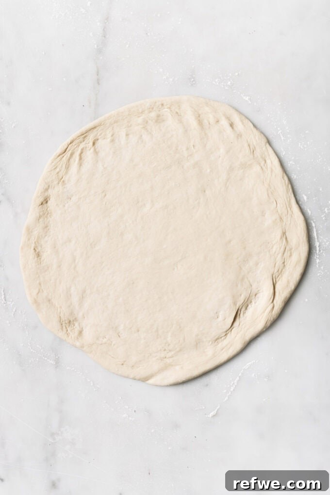 Sun-Kissed Mediterranean Pizza 4 rolled out pizza dough on a marble counter