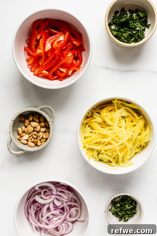 Zesty Thai Mango Salad 3 Individual bowls displaying all the fresh and colorful ingredients needed for the mango salad