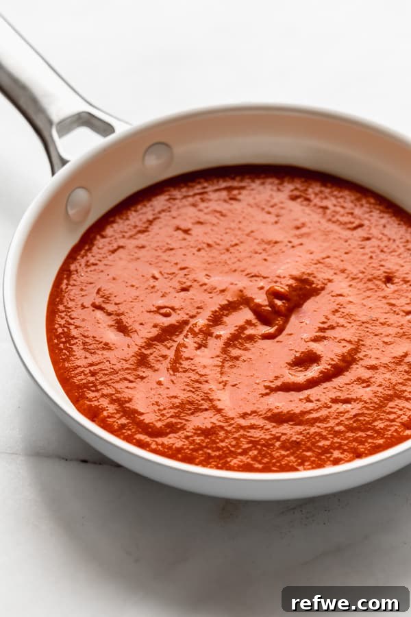 Velvety Vegan Roasted Red Pepper Pasta 3 Rich and vibrant roasted red pepper sauce simmering gently in a pan.