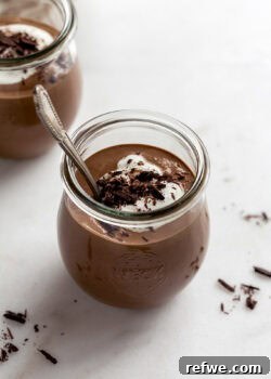 A cup of cottage cheese chocolate mousse topped with yogurt and chocolate shavings.
