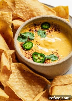 Cottage cheese queso with tortilla chips on a plate.