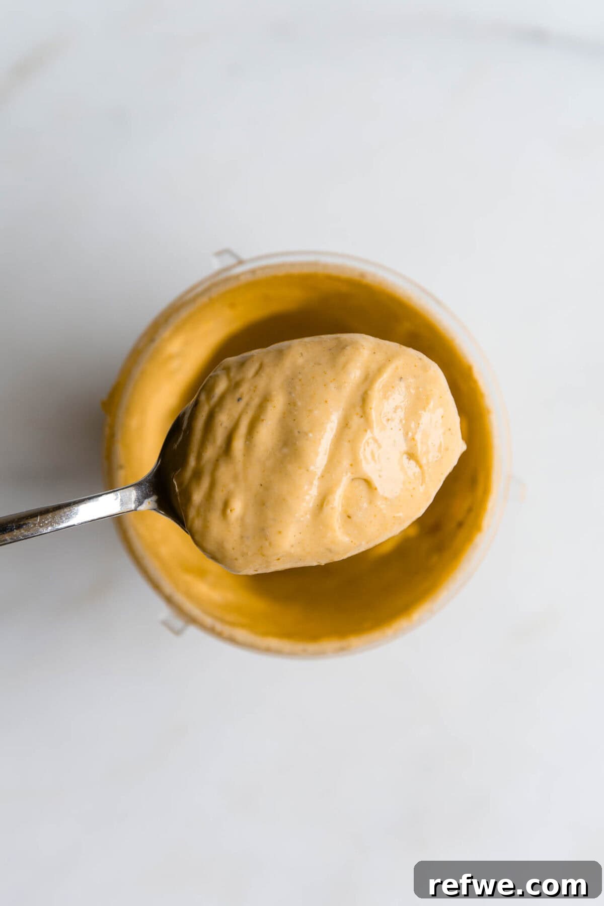 Whipped Cottage Queso Dip 5 A spoon scooping creamy, blended cottage cheese queso, showcasing its smooth and inviting texture.