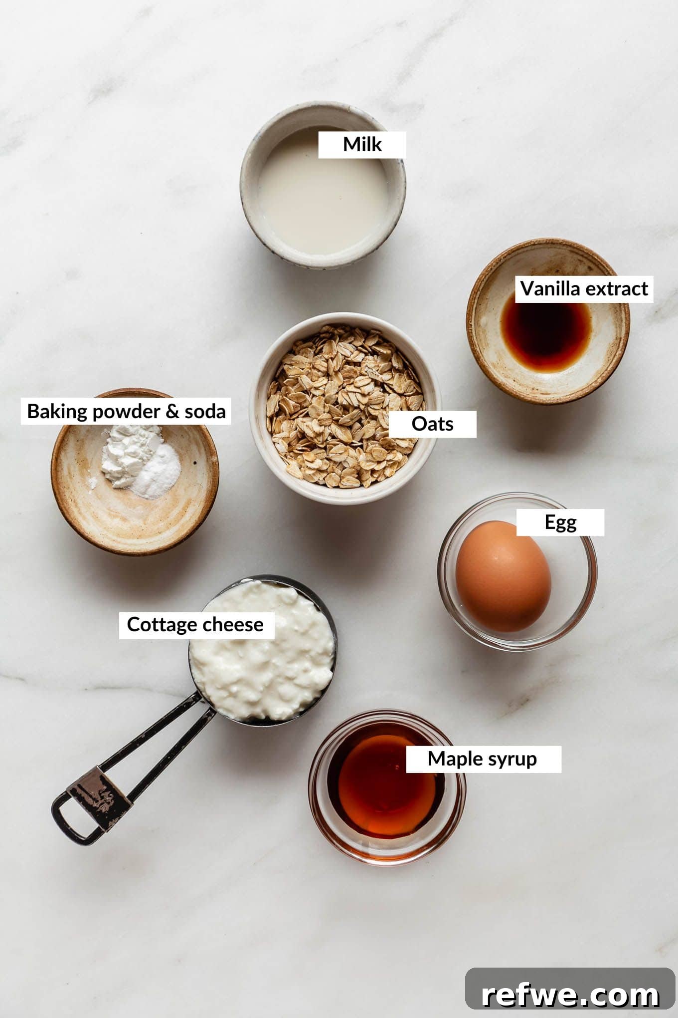 Peak Performance Pancake Bowl 3 A vibrant flat lay showcasing all the essential ingredients needed to create a delicious protein pancake bowl, neatly arranged on a kitchen counter.