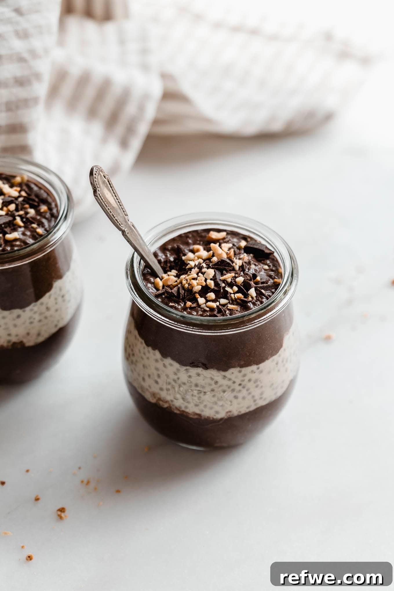 Peanut Butter Chocolate Chia Delight 9 A cup of chocolate peanut butter chia pudding with a spoon in it.