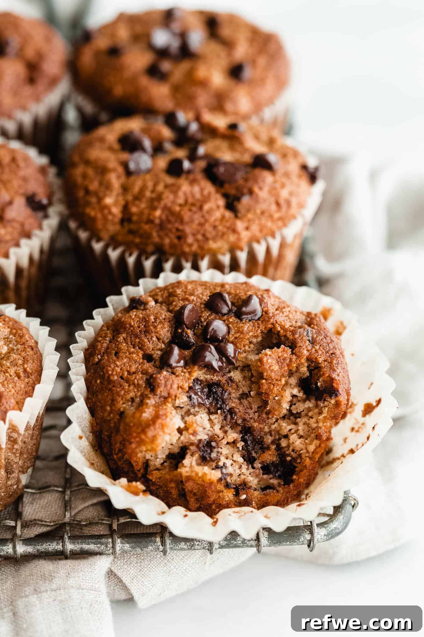 Wholesome Almond Banana Muffins 2 Golden brown almond flour banana muffins with chocolate chips on a cooling rack, ready to be enjoyed.