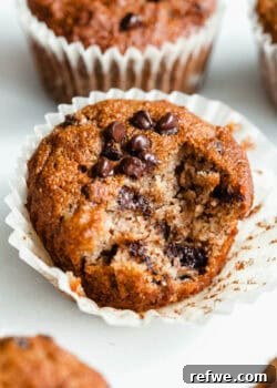 A perfectly baked banana almond flour muffin with a bite taken out, revealing its soft and moist interior.