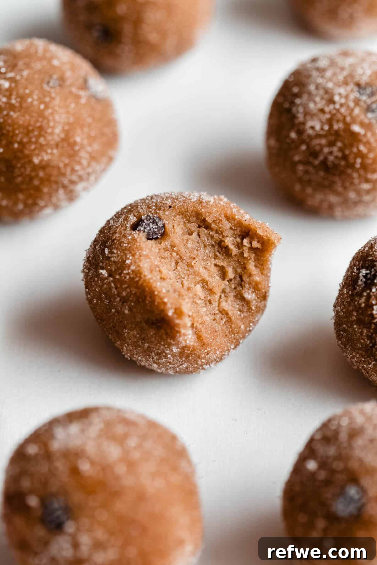 A delicious banana protein ball with a bite taken out, showing its soft, chewy texture and chocolate chips.