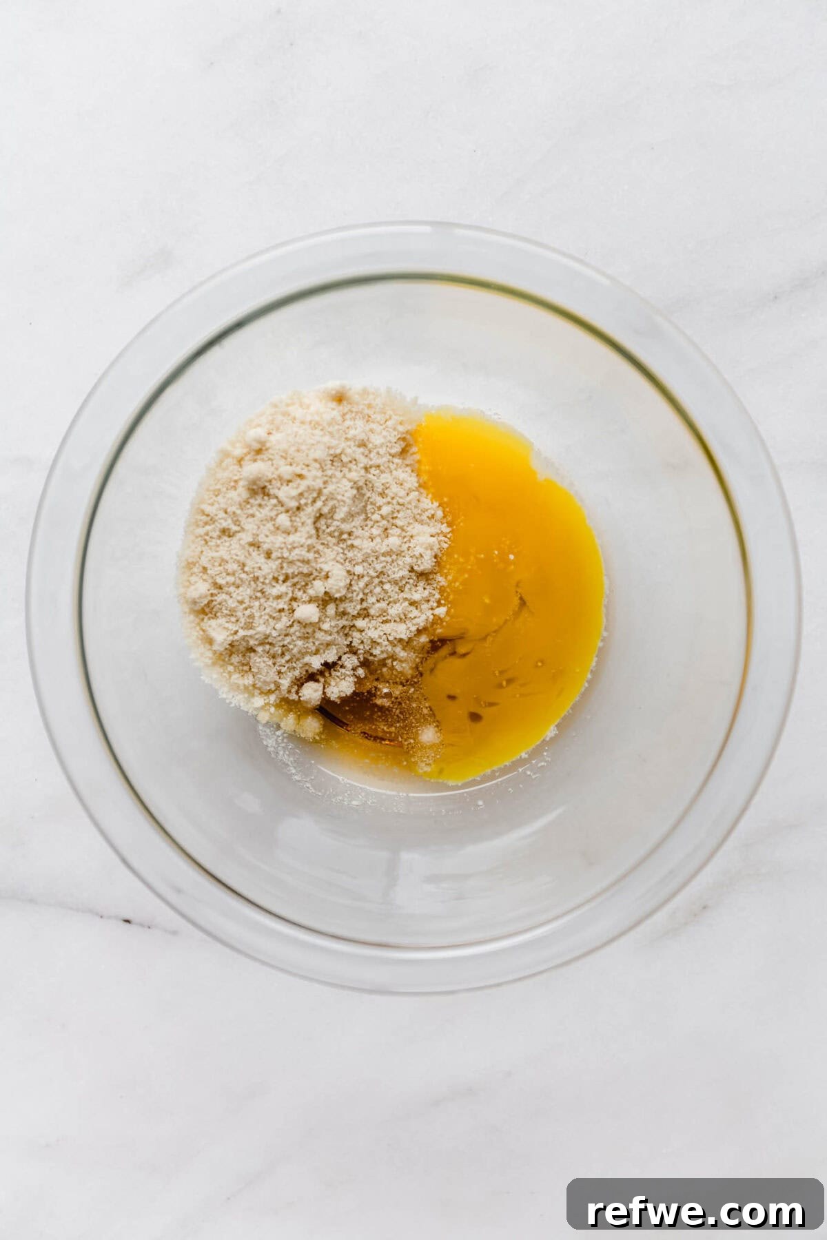 Almond paste filling ingredients, including almond flour, egg, and maple syrup, in a bowl.