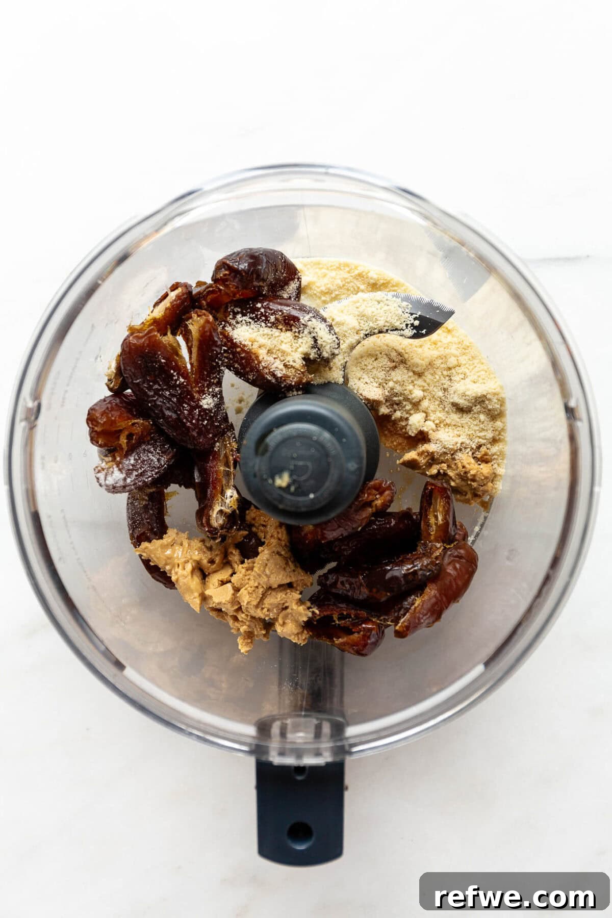 Date Caramel Chocolate Indulgence 4 Dates, cashew butter, and almond flour in a food processor, ready to be blended.