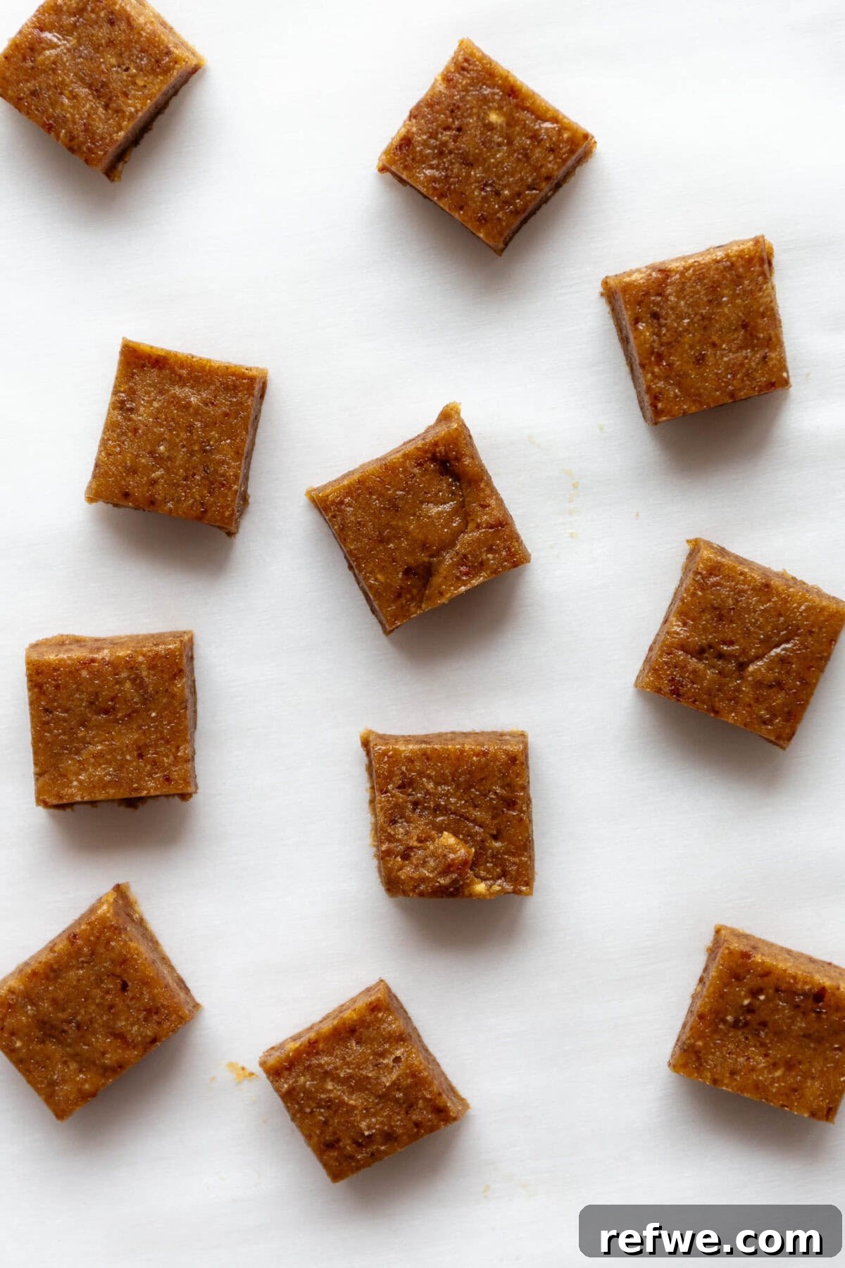 Date Caramel Chocolate Indulgence 7 Squares of date caramel neatly cut and arranged on parchment paper after chilling.