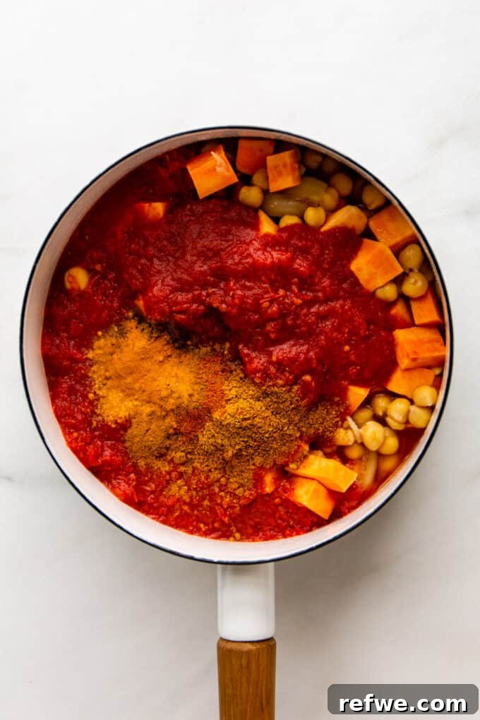 Fragrant Moroccan Chickpea Stew 5 Aromatic spices, crushed tomatoes, sweet potatoes, and chickpeas simmering in a pot.