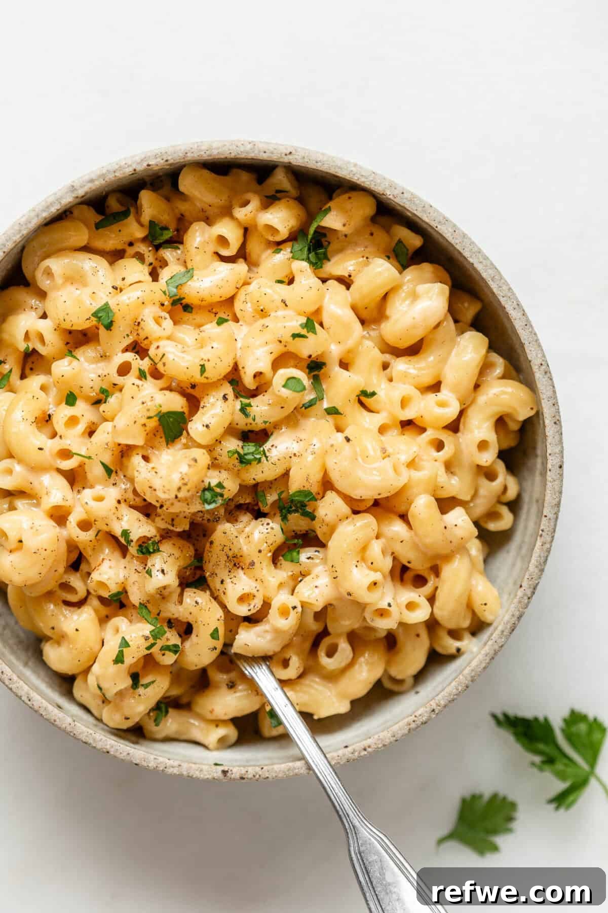 15-Minute Cottage Cheese Mac & Cheese Delight 8 A close-up shot of a comforting bowl of cottage cheese mac and cheese with a spoon, highlighting its creamy texture.