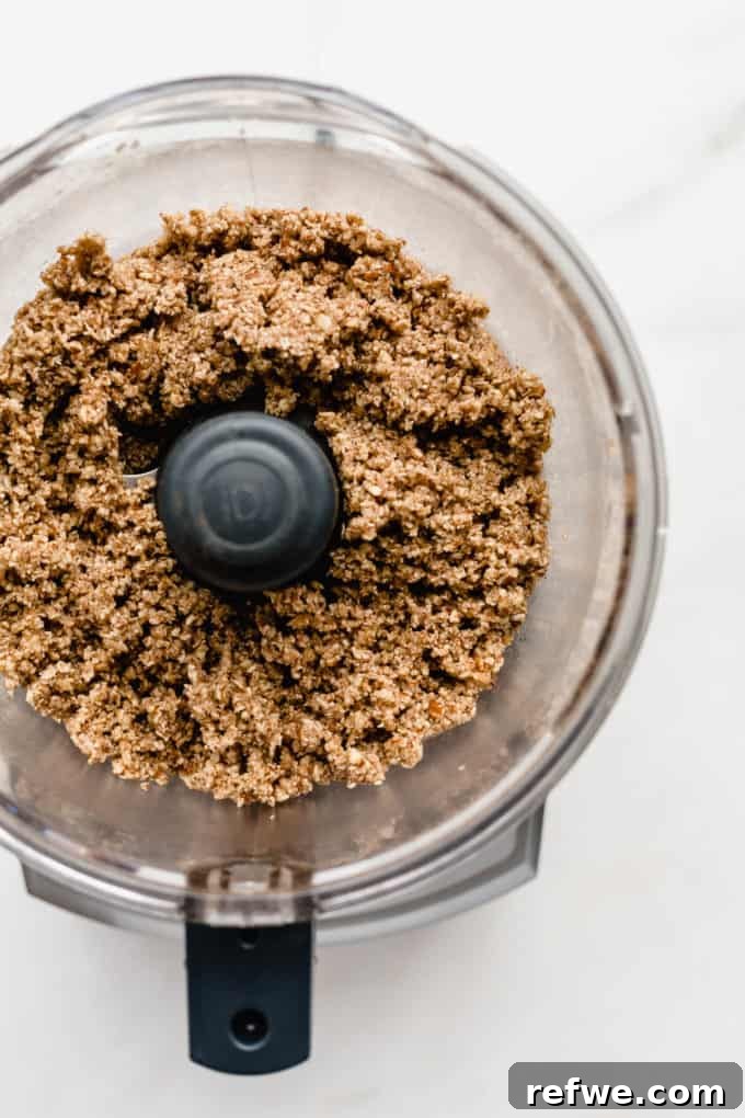 Guilt-Free Mini Pecan Treats 4 A food processor bowl containing the perfectly blended pecan pie crust mixture, showing its crumbly yet cohesive texture, ready to be pressed into tart pans.