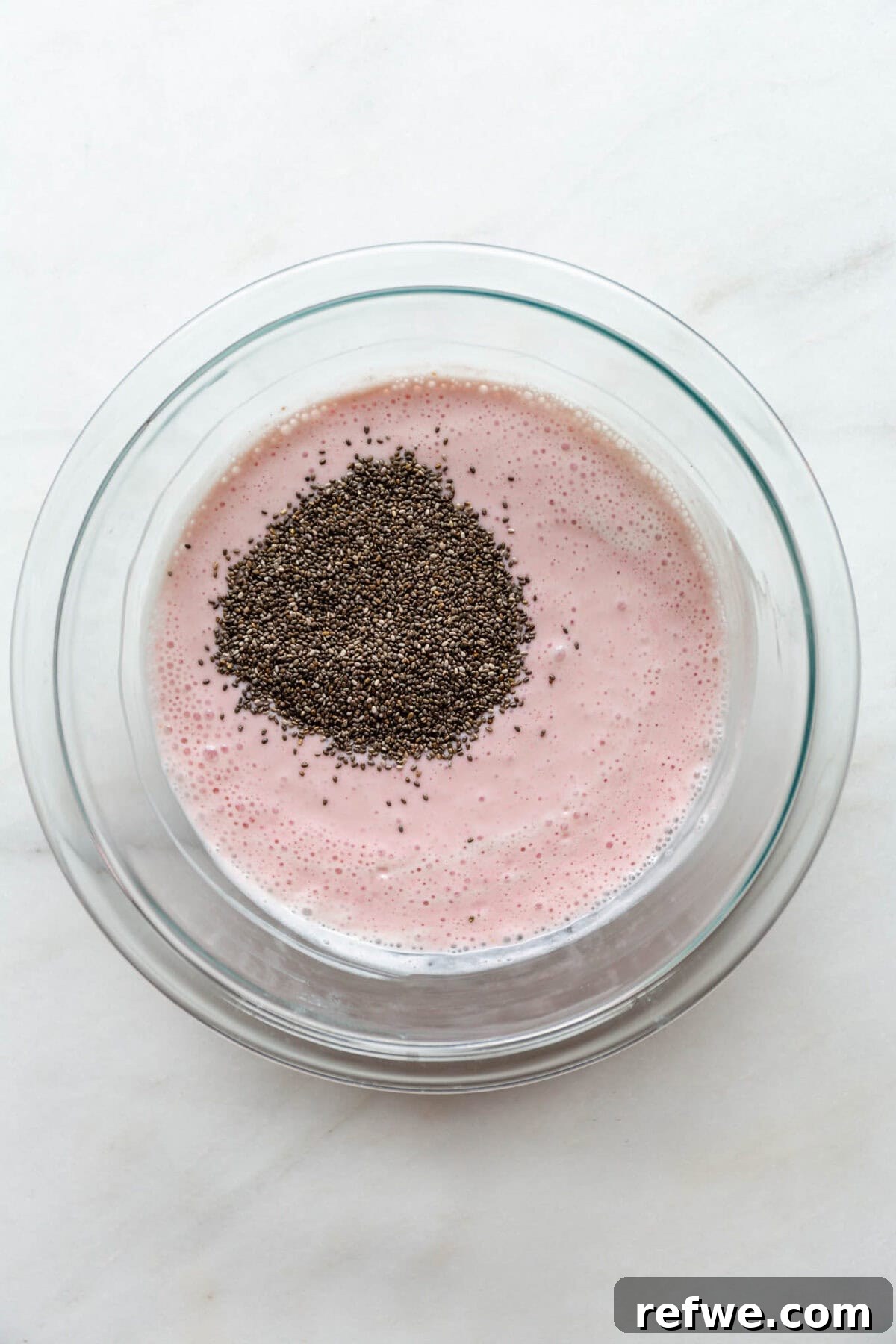Supercharged Protein Chia Pudding 6 Blended raspberry cottage cheese in a clear bowl with chia seeds.
