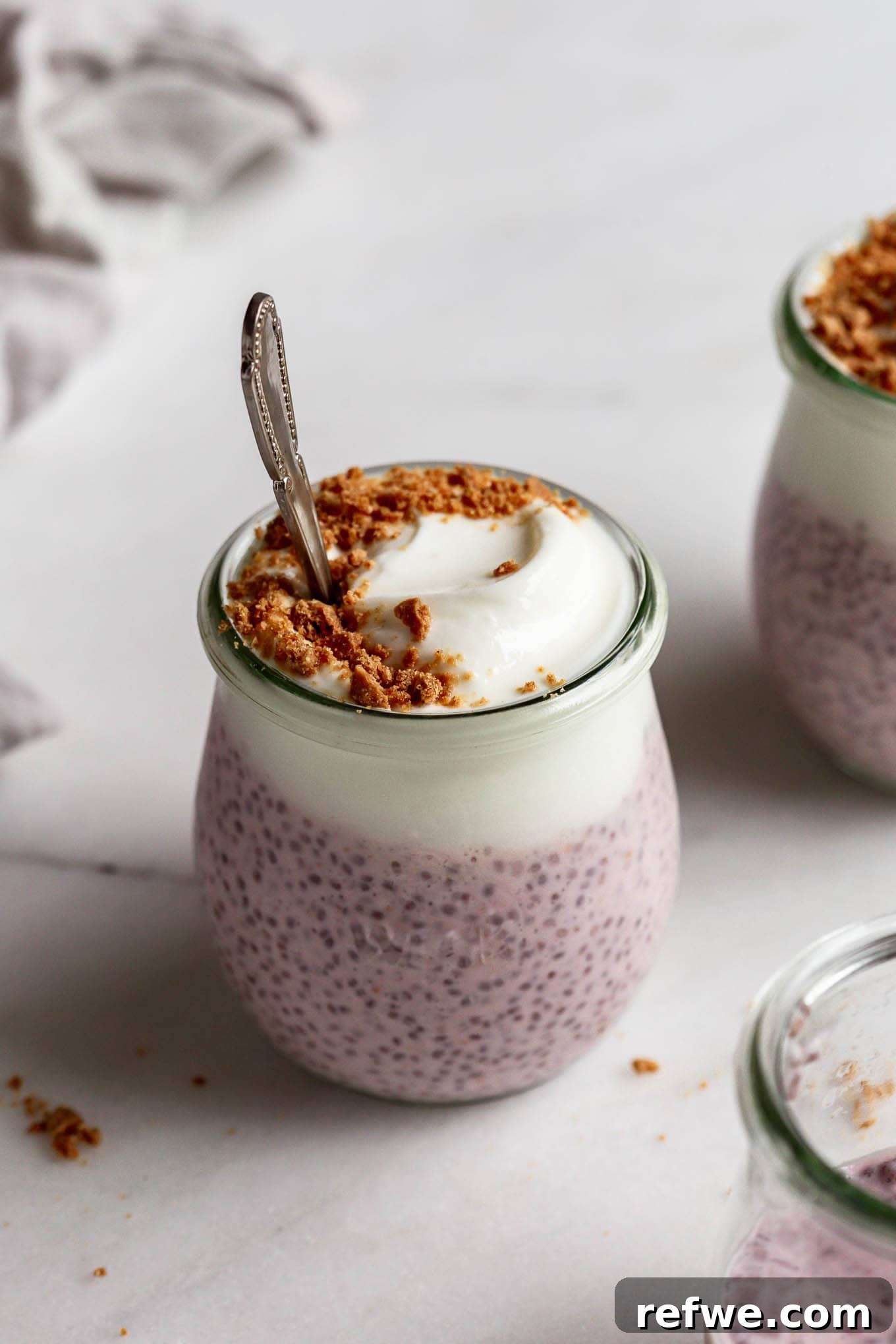 Supercharged Protein Chia Pudding 8 Protein chia pudding in a cup topped with graham cracker crumbs and a spoon in it.