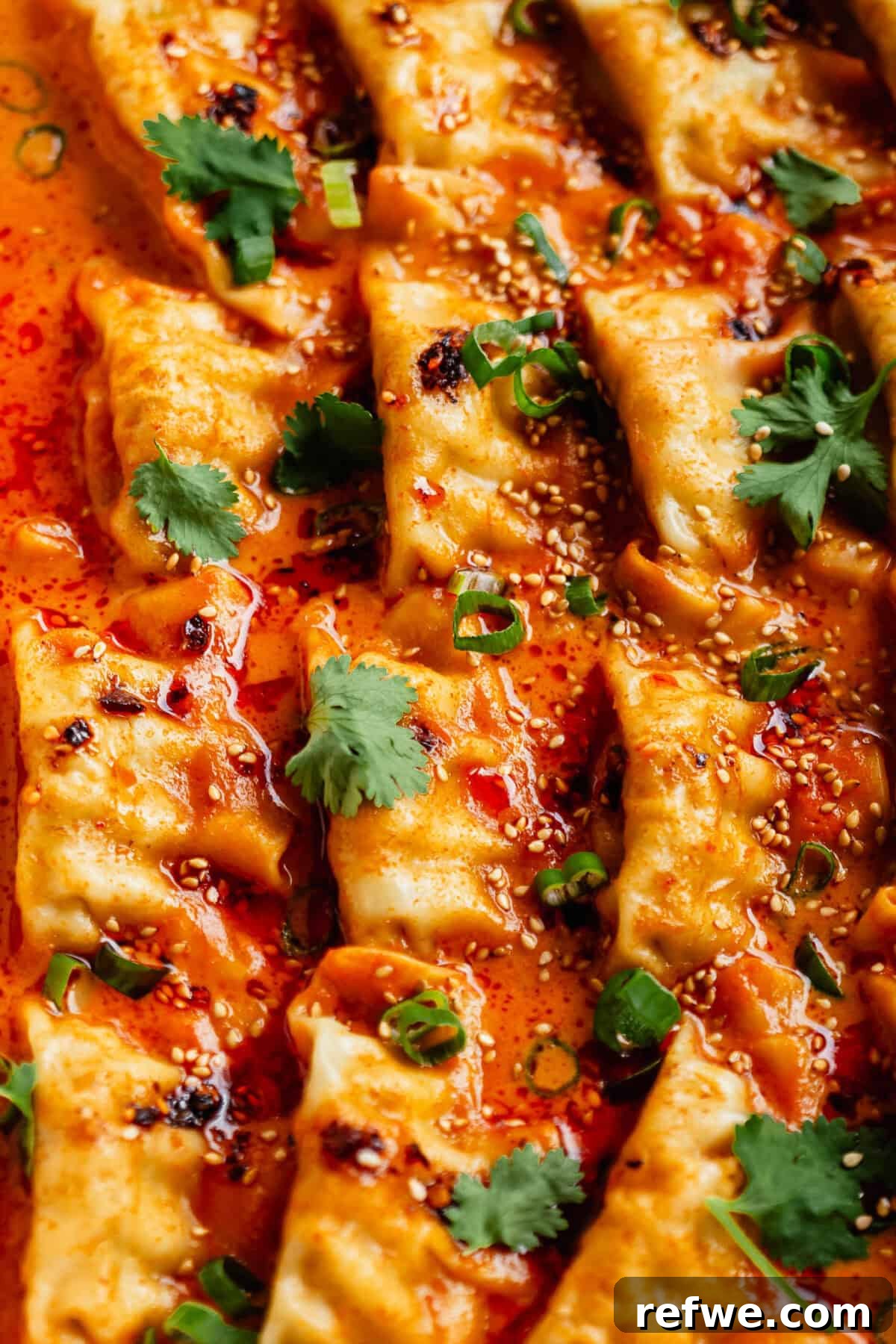 Sheet Pan Dumpling Bake 8 Beautifully baked curry dumplings, garnished with fresh cilantro and sesame seeds, ready to be enjoyed.