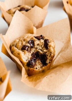 A protein banana muffin with a bite taken out of it, showing its perfectly baked, fluffy texture.
