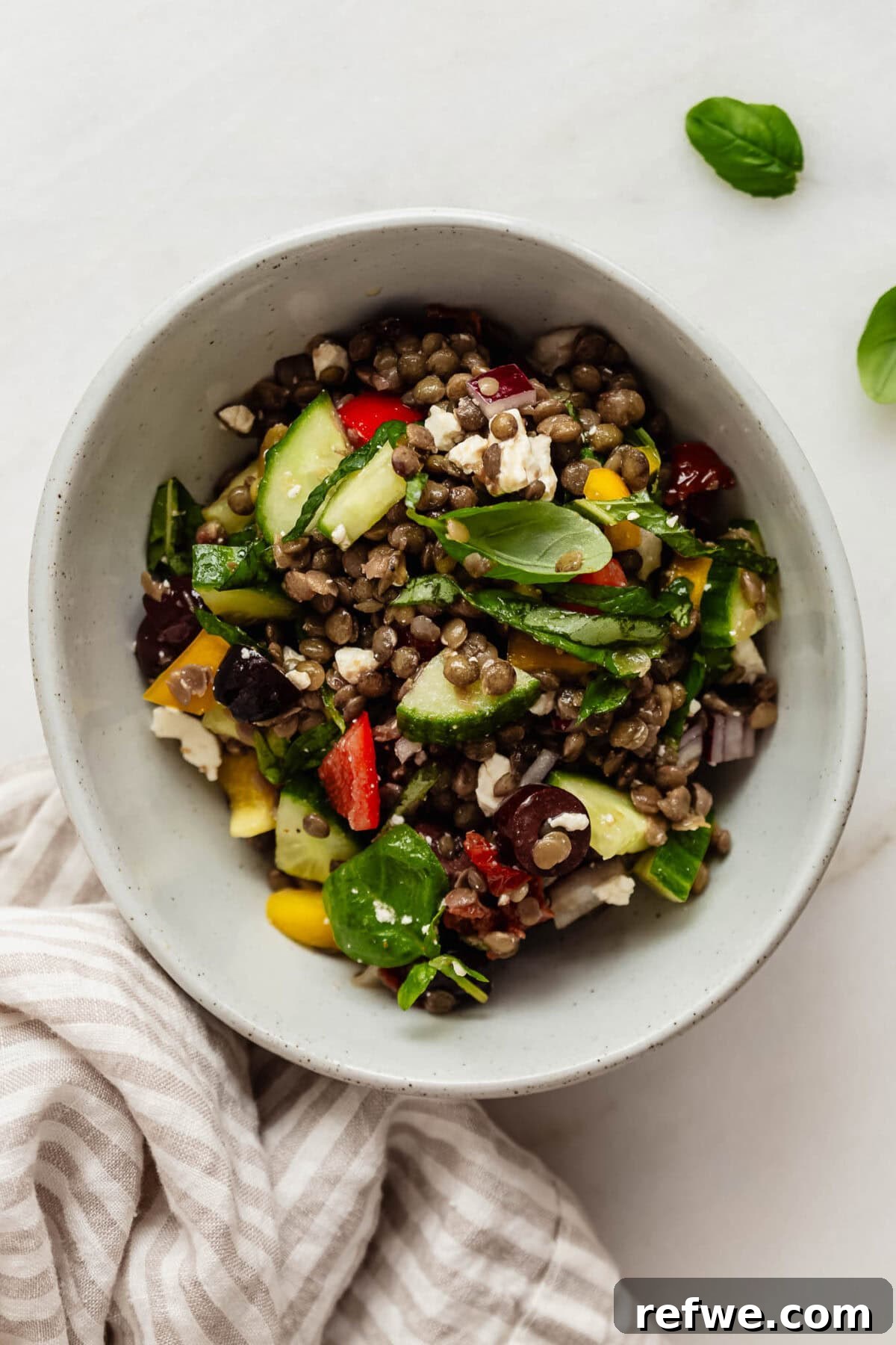 Vibrant Mediterranean Lentil Salad 6 A large, inviting bowl of Mediterranean lentil salad, artfully arranged to showcase its vibrant colors and fresh ingredients, ready to be enjoyed as a wholesome meal.