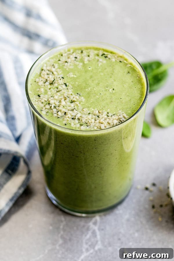 My Go-To Green Elixir 3 Close-up of a refreshing green smoothie in a tall glass, garnished with fresh mint leaves, showcasing its vibrant color