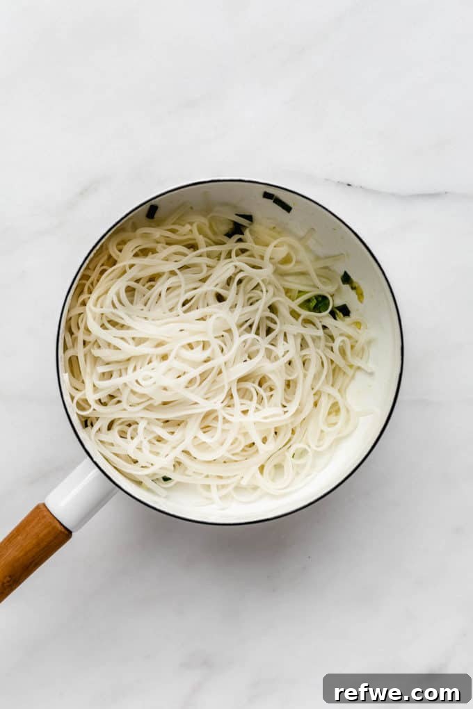 Peanut Butter Noodle Bliss 5 A white pot filled with perfectly cooked rice noodles, ready to be tossed with sauce.