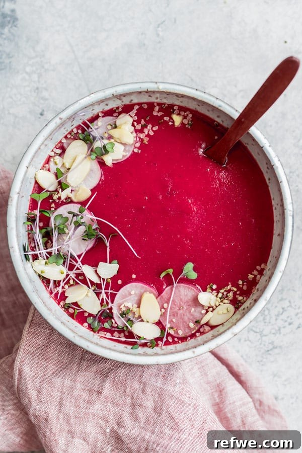 Hearty Vegan Beet Potato Leek Soup 6 Overhead shot of vegan beet, potato, and leek soup, with a spoon resting in the bowl.