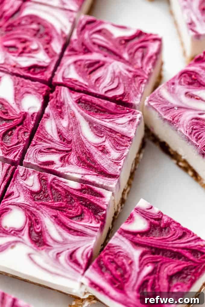 Decadent Vegan Raspberry Cheesecake Bars 12 Sliced vegan raspberry cheesecake bars cut into perfect squares on a marble board, ready to serve
