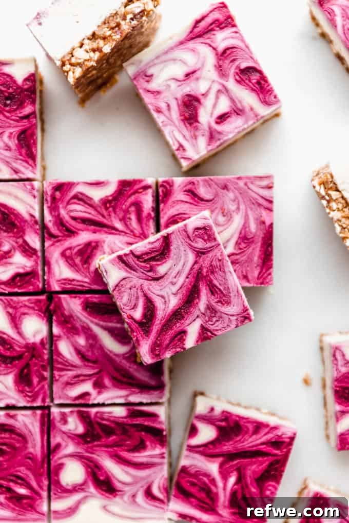 Decadent Vegan Raspberry Cheesecake Bars 14 Vegan raspberry cheesecake bars cut into squares on a marble board, garnished with fresh raspberries