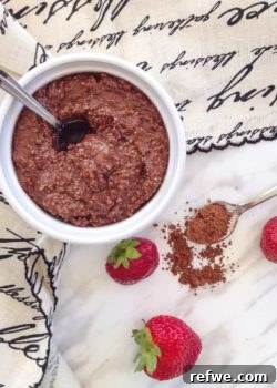 Homemade Ferrero Rocher spread in a glass jar with fresh hazelnuts.