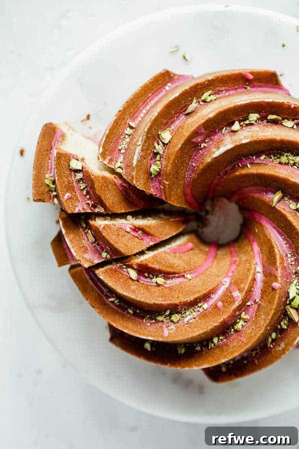 Your First Perfect Plate: Food Photography Basics 12 An elegant orange cardamom bundt cake on a cake stand with pink blood orange glaze and chopped pistachios, perfectly composed.