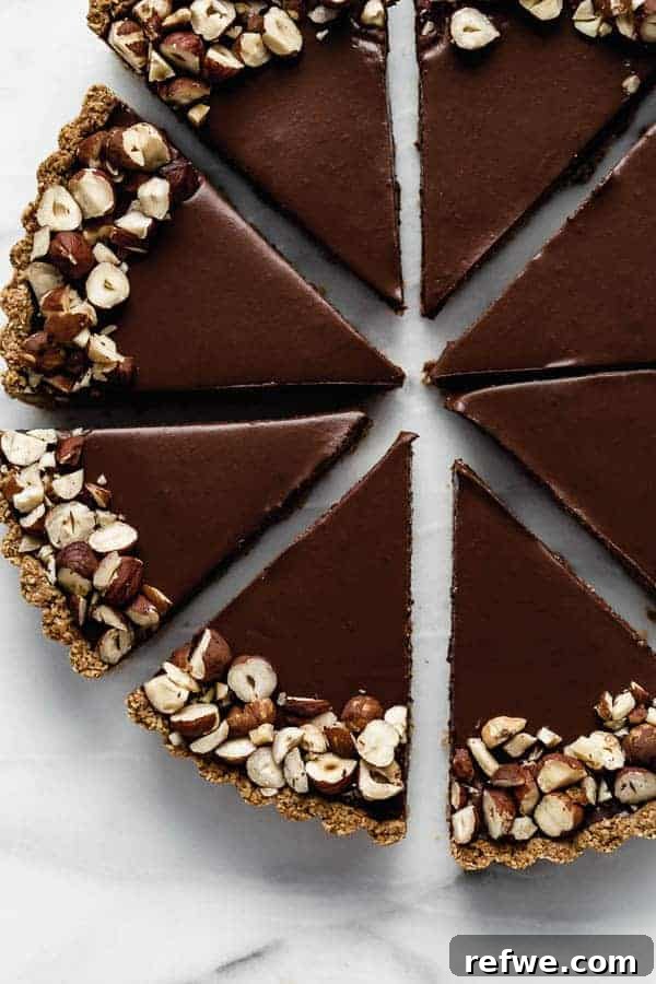 Your First Perfect Plate: Food Photography Basics 6 Decadent vegan chocolate hazelnut tart with a glossy glaze, demonstrating excellent use of diffused backlighting.