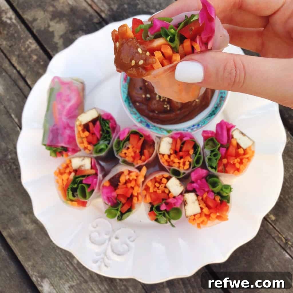 Vibrant Veggie Wraps with Silky Peanut Sauce 3 Delicious spring rolls ready to be served with peanut sauce