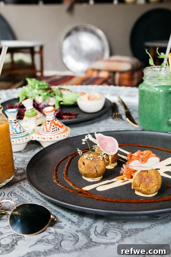 Almond falafel, fresh salads, and smoothies on a table at Macondo Tulum