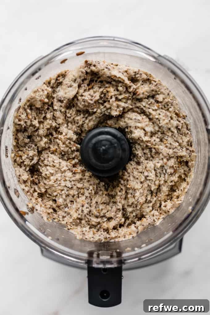 Wholesome Chia Buckwheat Loaf 6 The interior of a food processor bowl, showing the buckwheat groats and chia seeds perfectly blended into a thick, uniform dough consistency.